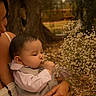 baby, child, flower, bouquet, nature, outdoor, person, holding, tattoo, hand, clothing, suit, white_flower, closeup, portrait, peaceful, soft_light, tree, adult, skin