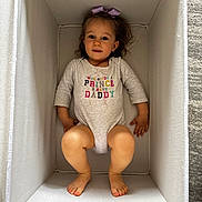 Aelita Misha is registered to the contest to win money with this photo: toddler, child, girl, onesie, bow, purple_bow, box, white_box, feet, barefoot, smiling, looking_at_camera, indoors, carpet, cute, clothing, casual, portrait, happy, baby