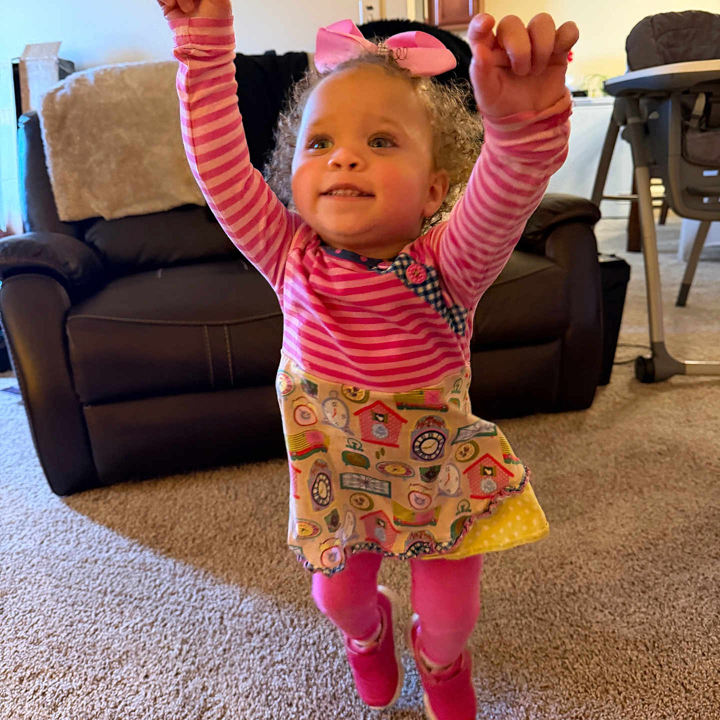 Jor Ja joined the competition — help win amazing prizes! toddler, child, jumping, pink_shoes, striped_shirt, colorful_dress, living_room, carpet, couch, high_chair, smiling, happy, arms_up, bow, curly_hair, indoor, furniture, portrait, person, playful