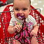 baby, pacifier, shopping_cart, blanket, child, smiling, indoor, clothing, person, cute, infant, hand, seat, retail, store, toy, fabric, portrait, happy, young_child