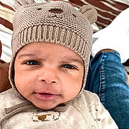 Daniel a rejoint le concours — aidez-le/la à gagner de superbes lots ! baby, infant, face, hat, knit_hat, beanie, eyes, smile, onesie, pajamas, bedding, striped_bed, blanket, close_up, portrait, cozy, denim, hand, indoor, cute