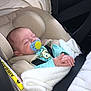 baby, infant, car_seat, pacifier, blanket, sleeping, child, seatbelt, clothing, head_support, indoor, transportation, safety, cute, peaceful, resting, soft_texture, newborn, person, toddler