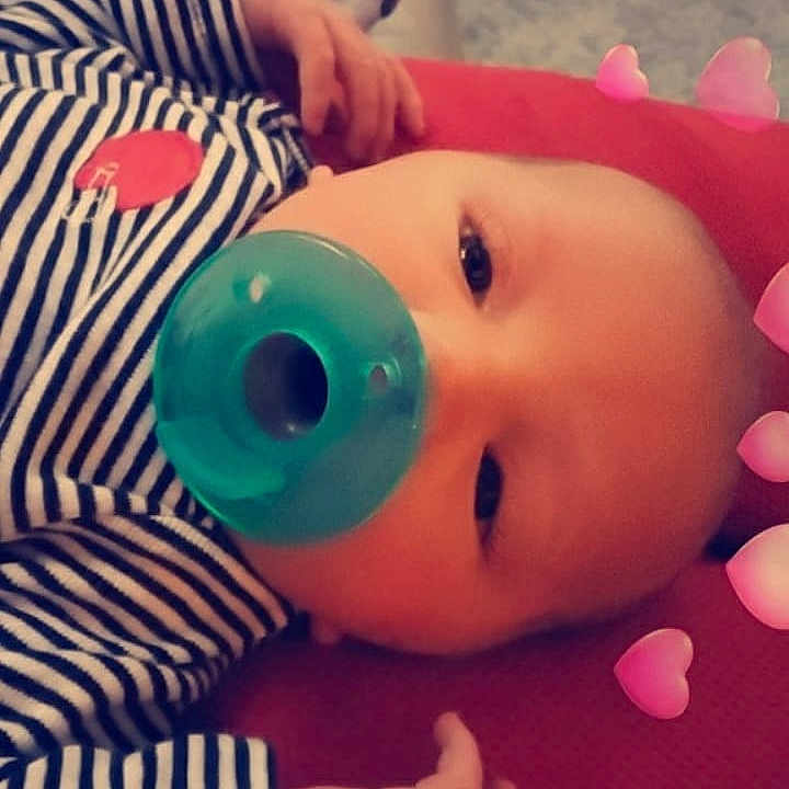 Travis is registered to the contest to win money with this photo: cheek, child, close_up, ear, eye, face, finger, forehead, hand, head, infant, lip, mouth, nose, organ, pink, skin, textile, toddler, toy