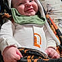 animal_print, baby, blanket, child, clothing, cozy, cute, face, green_bib, hand, happy, indoor, infant, lying_down, newborn, pillow, portrait, smiling, soft_texture, tiger_stripe