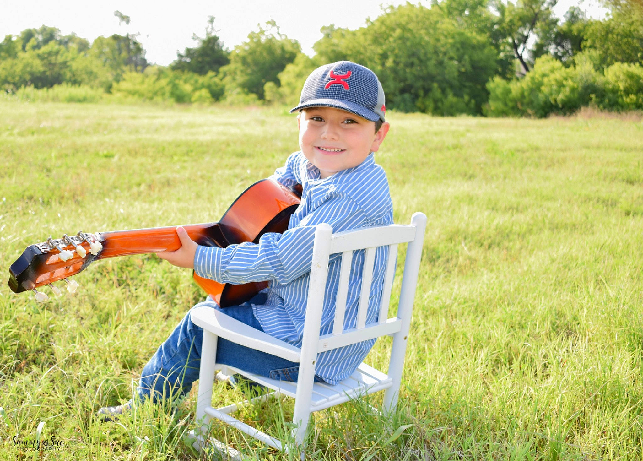 Braiden is registered to the contest to win money with this photo: child, farm, grass, grass_family, grassland, headwear, joy, leisure, meadow, pasture, people_in_nature, person, plant, play, prairie, recreation, sitting