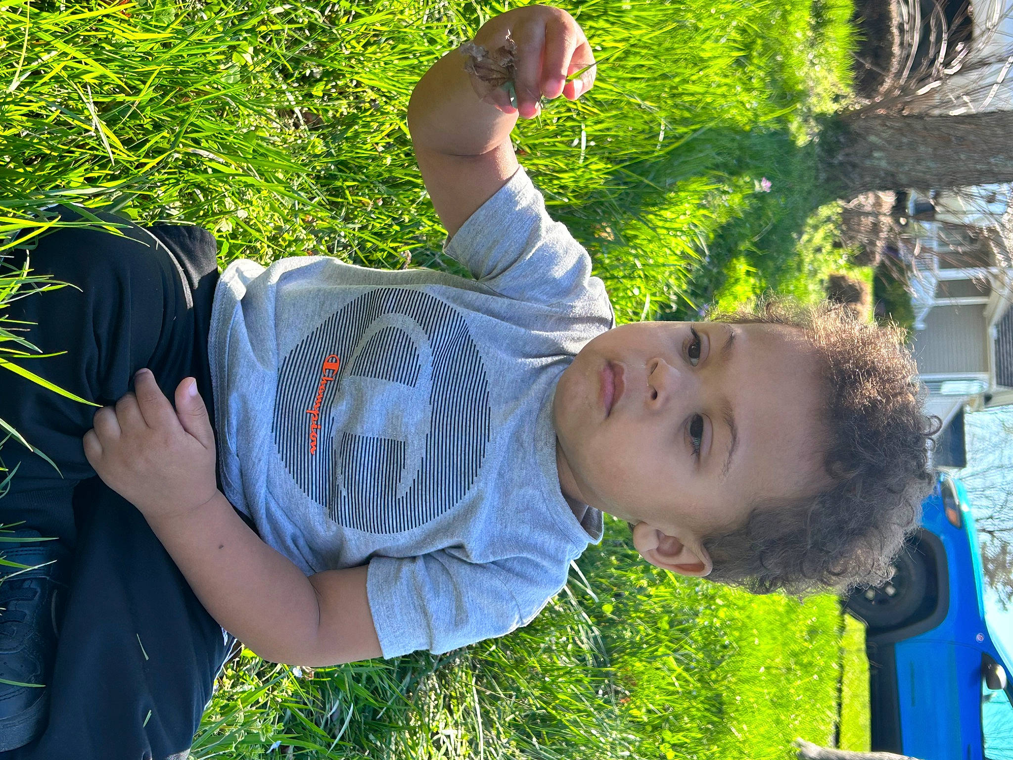 Malaki joined the competition — help win amazing prizes! child, elbow, eyewear, fun, gesture, grass, grassland, green, happy, leisure, people_in_nature, person, plant, sitting, spring, sunglasses, sunlight, t_shirt, toddler, tree