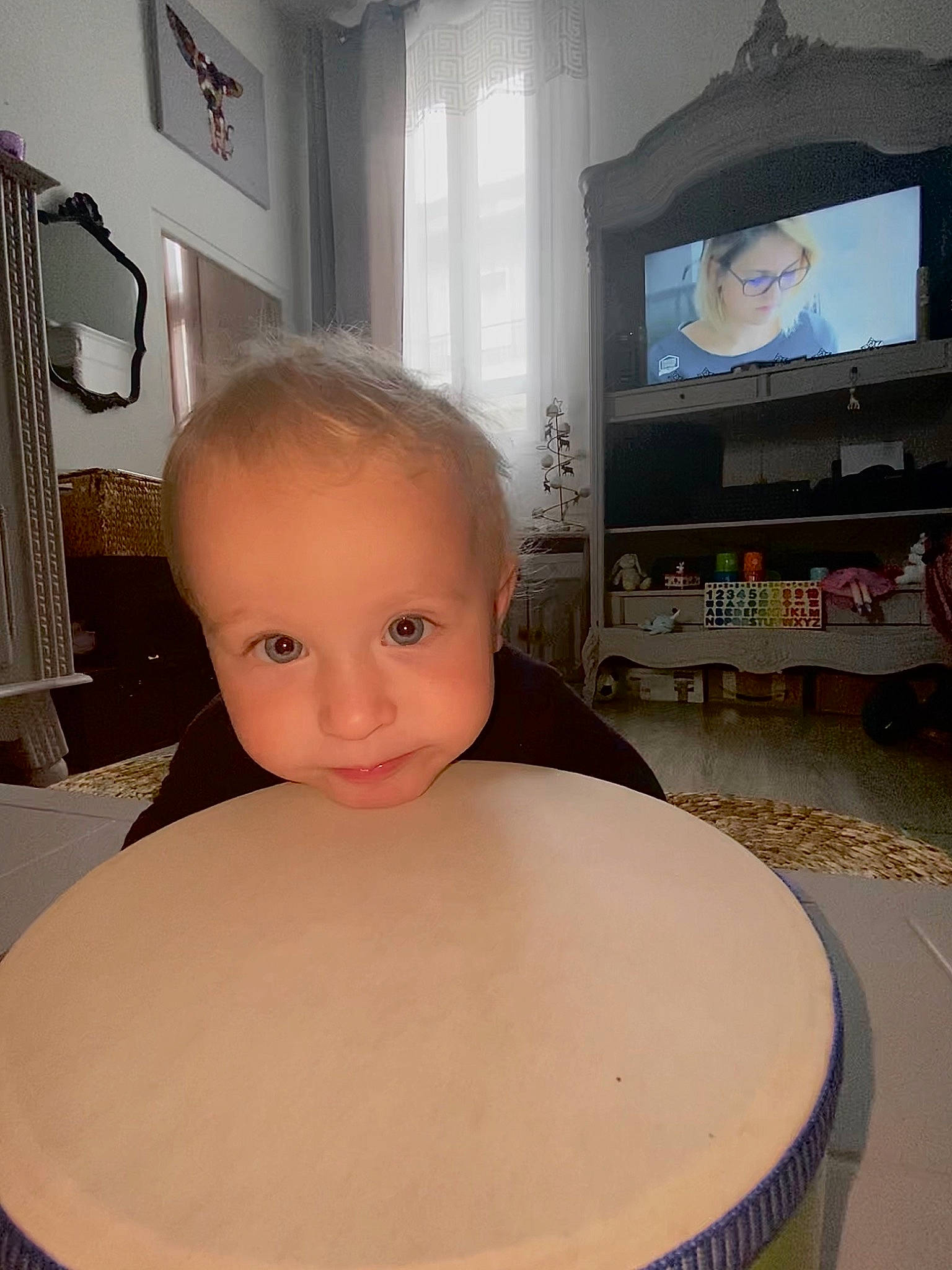 Thaÿs participe au concours pour gagner de l'argent avec cette photo : cable_television, child, chin, drum, entertainment_center, flat_panel_display, flooring, hand_drum, hardwood, home_appliance, idiophone, membranophone, musical_instrument, output_device, person, picture_frame, standing, television, television_set, toddler