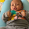baby, infant, pacifier, clothing, sweatshirt, person, face, hand, legs, indoor, home, furniture, sitting, child, cute, expression, relaxed, casual, background, shelf