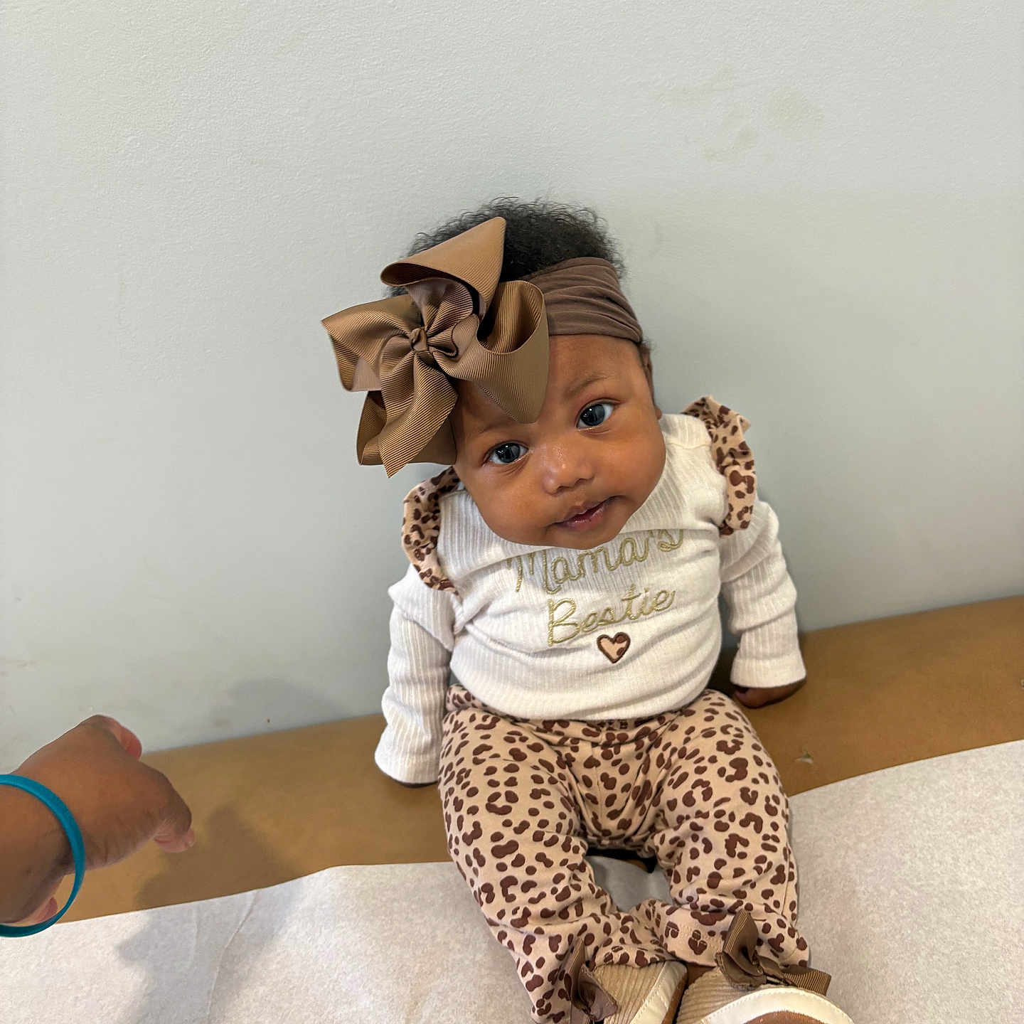 Ameri joined the competition — help win amazing prizes! baby, infant, child, portrait, sitting, smiling, bow, headband, leopard_print, outfit, shoes, fashion, brown, white, indoor, changing_table, wall, hand, adorable, photography