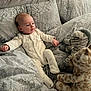 baby, infant, bed, bedding, pillow, plush_toy, giraffe, zebra, sleepwear, onesie, pattern, headboard, soft_toys, indoor, cute, child, resting, comfort, young, blanket