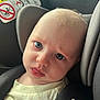 Kairo is registered to the contest to win money with this photo: baby, child, car_seat, infant, face, tongue, blue_eyes, close_up, seat_belt, warning_sign, hair, clothing, indoor, car, headrest, expression, skin, person, seat, safety