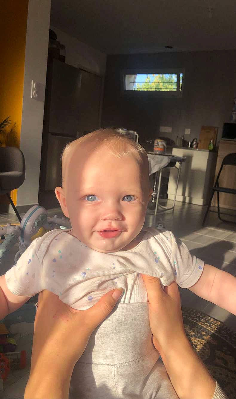 Louis participe au concours pour gagner de l'argent avec cette photo : arm, baby, baby_toddler_clothing, chair, cheek, chin, ear, eye, floor, flooring, furniture, iris, mouth, muscle, person, skin, smile, standing, television, toddler