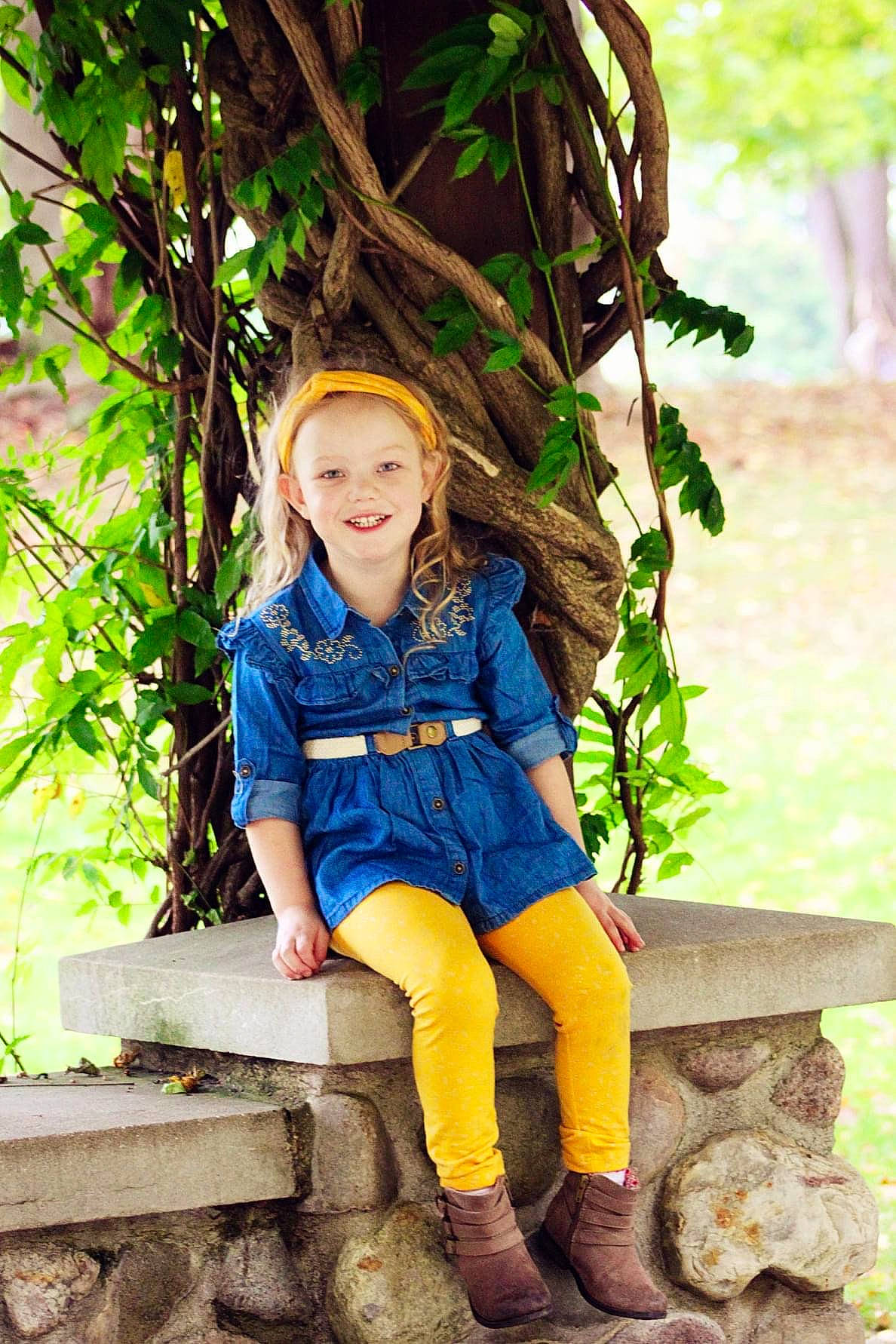 Emily is registered to the contest to win money with this photo: botany, fawn, flash_photography, forest, grass, happy, iris, joy, leaf, leisure, long_hair, outerwear, people_in_nature, person, plant, smile, summer, thigh, toddler, tree