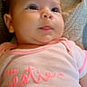 Makenzie joined the competition — help win amazing prizes! baby, infant, onesie, pink_clothing, blanket, phone, face, head, skin, cute, lying_down, soft_surface, expression, newborn, child, person, indoors, portrait, chubby_cheeks, curious