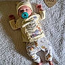 Oaklei Storm is registered to the contest to win money with this photo: baby, infant, pacifier, hat, yellow_clothing, pajamas, blanket, wooden_sign, one_month, lying_down, cute, soft_texture, indoor, child, newborn, foot, hand, sleepy, portrait, milestone