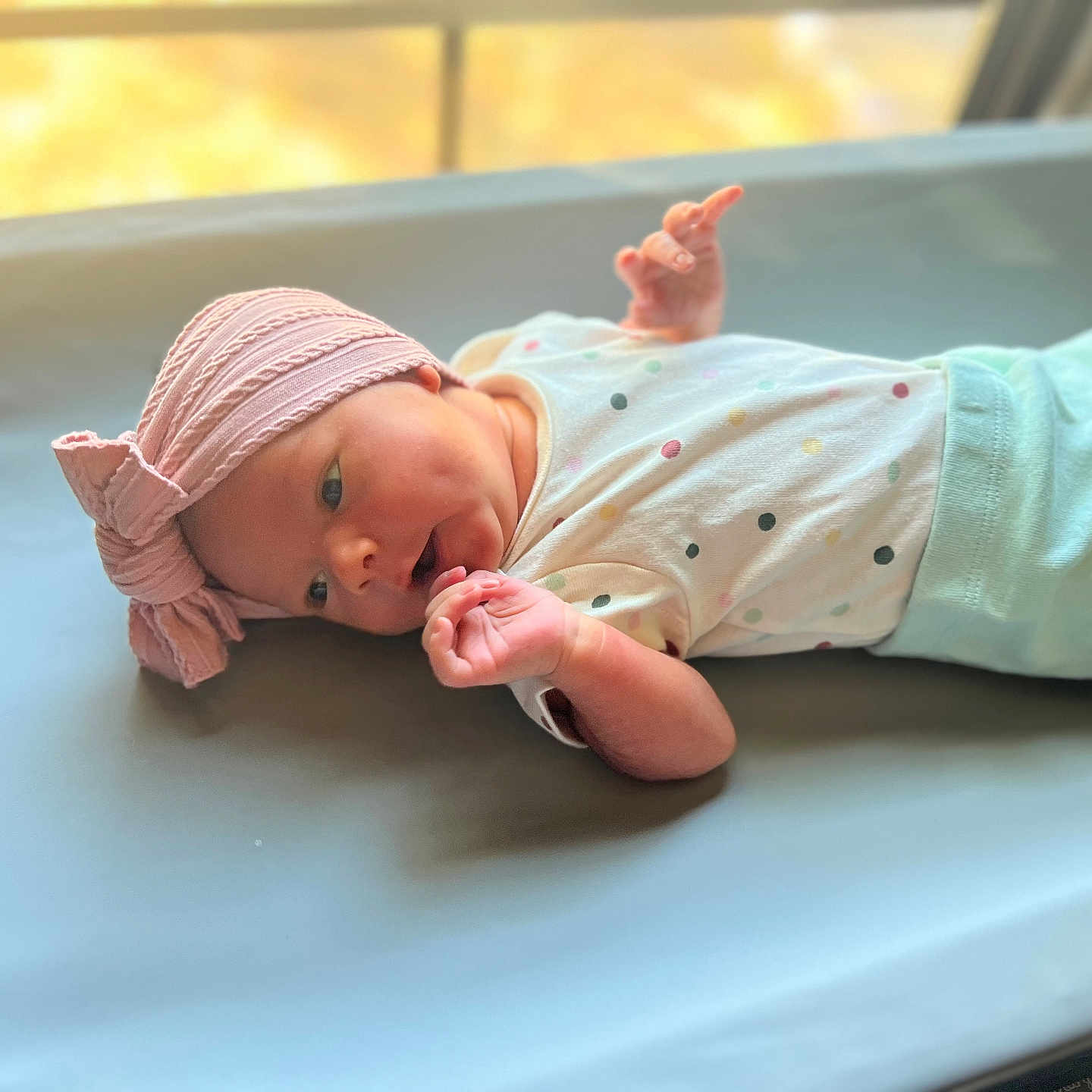 Zaeana is registered to the contest to win money with this photo: baby, changing_mat, clothing, cozy, cute, expression, face, hand, hat, indoors, infant, lying_down, newborn, pink, polka_dots, resting, skin, small_hands, soft_light, window_light