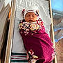 Zaeana is registered to the contest to win money with this photo: newborn, baby, swaddled, blanket, hat, sleeping, hospital, bassinet, infant, portrait, person, cute, floral, clothing, resting, indoors, soft_light, peaceful, wrapped, child