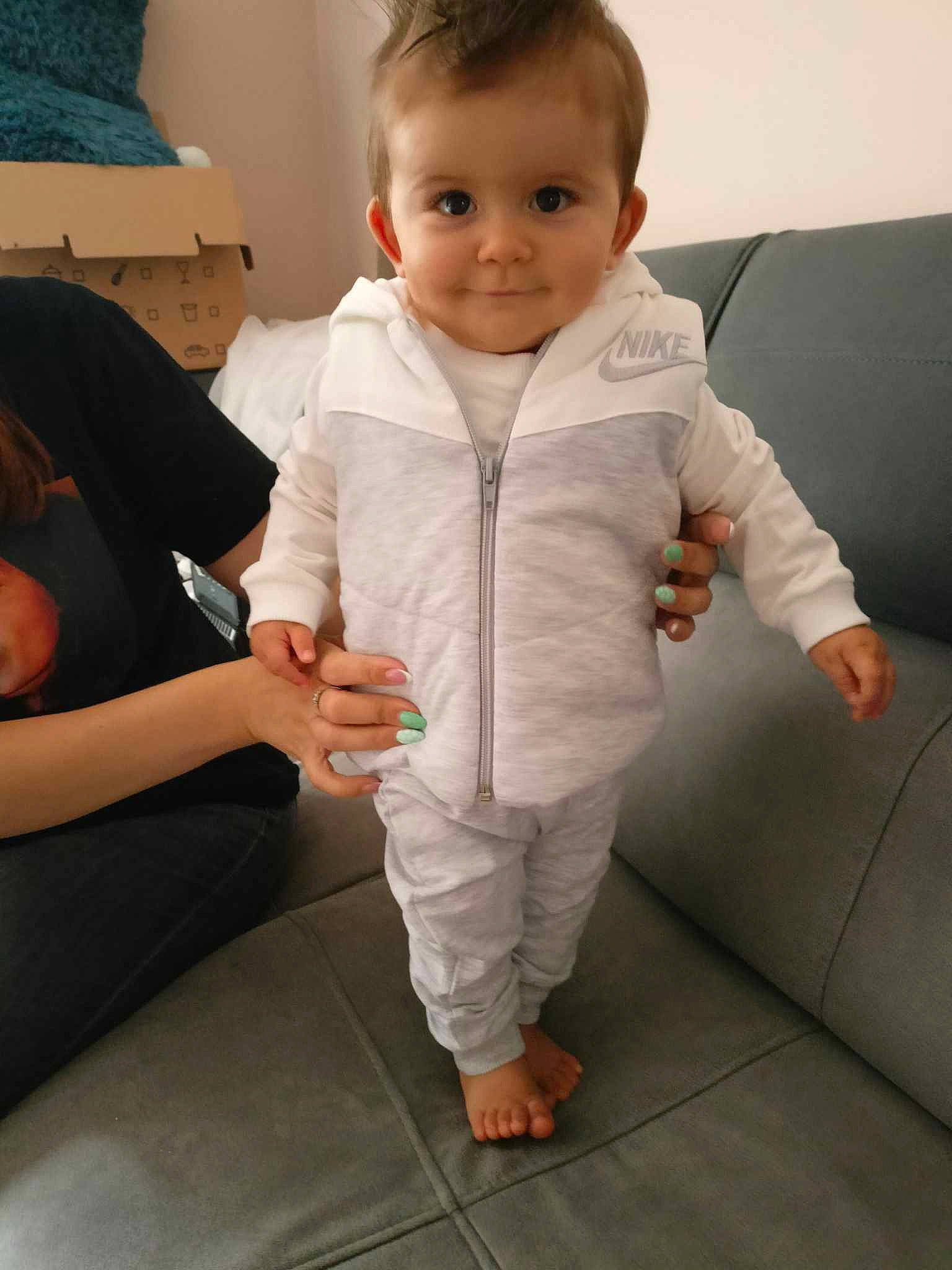 Aïdan participe au concours pour gagner de l'argent avec cette photo : baby, baby_toddler_clothing, cheek, child, comfort, couch, flooring, foot, gesture, hair, hand, happy, head, human_body, person, sitting, skin, sleeve, smile, thumb