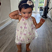 Gianna Tess joined the competition — help win amazing prizes! barefoot, bracelet, child, curious, cute, dress, floor, flower, garden, glass_door, headband, home, indoor, person, radiator, smiling, standing, toddler, window, wooden_floor
