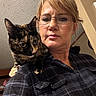 Luna joined the competition — help win amazing prizes! woman, cat, glasses, plaid_shirt, indoor, shoulder, tortoiseshell_cat, pet, person, portrait, animal, feline, casual, home, curious, face, looking_away, short_hair, eyewear, closeup