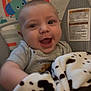 animal_print, baby, baby_seat, blanket, cartoon, child, clothing, comfort, cute, fabric, face, happy, indoor, infant, playful, portrait, seat, smiling, toy, young_child