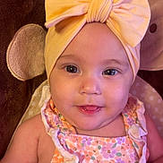 Aaliyah is registered to the contest to win money with this photo: arm, baby, blanket, bow, child, closeup, cute, eyes, face, floral_dress, happy, headband, indoors, infant, lying_down, pattern, portrait, skin, smile, soft