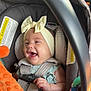 Aaliyah joined the competition — help win amazing prizes! baby, car_seat, headband, bow, toy, orange, smiling, happy, infant, child, safety_strap, clothing, seatbelt, cute, indoors, hand, face, person, car_interior, playful