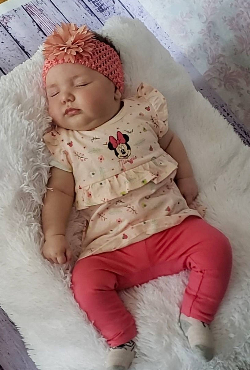 Sarah participe au concours pour gagner de l'argent avec cette photo : baby, baby_products, baby_sleeping, baby_toddler_clothing, bedding, cap, child, comfort, fashion_accessory, headgear, headwear, linens, magenta, pattern, peach, person, pink, sitting, skin, sleeve