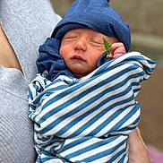 Everitt joined the competition — help win amazing prizes! newborn, baby, sleeping, hat, blue, striped_blanket, leaf, hand, adult, holding, cozy, closeup, portrait, soft_focus, outdoor, skin, face, peaceful, infant, wrapped