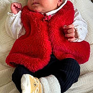 Mia a rejoint le concours — aidez-le/la à gagner de superbes lots ! baby, newborn, sleeping, red_vest, white_shirt, black_pants, bear_socks, blanket, infant, cute, cozy, soft_texture, clothing, portrait, peaceful, hands, face, head, resting, indoor