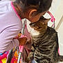 Tigger joined the competition — help win amazing prizes! child, cat, tabby_cat, toy_stroller, pink, indoor, play_mat, colorful, close_up, cute, pet, interaction, home, furniture, toy, young_child, cuddly, comfort, curious, small