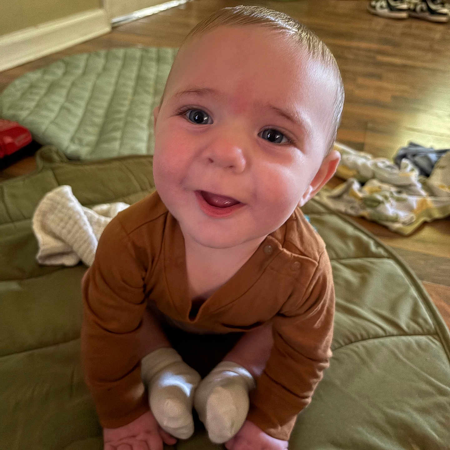 Kanen is registered to the contest to win money with this photo: baby, brown_clothing, child, cozy, crawling, cute, face, feet, floor, hands, happy, home, indoor, infant, mat, person, quilted, smiling, white_socks, wooden_floor