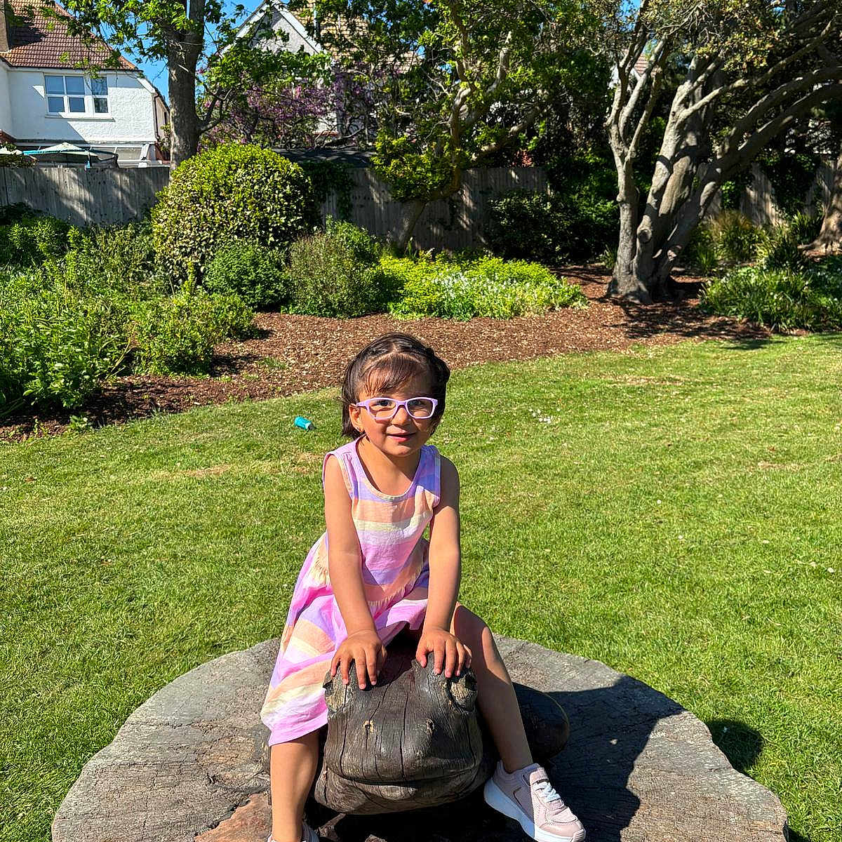 Kiara joined the competition — help win amazing prizes! child, daylight, dress, frog, garden, glasses, grass, greenery, happy, nature, outdoor, park, play, sculpture, shoes, smiling, sunlight, trees, wooden_sculpture, young