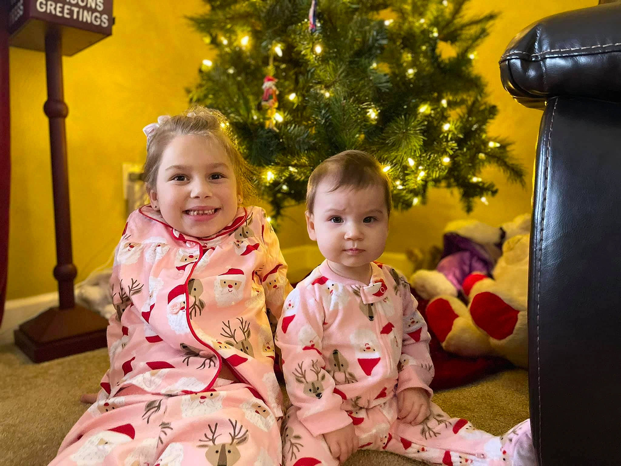 Mia is registered to the contest to win money with this photo: baby_toddler_clothing, cheek, child, christmas, christmas_decoration, christmas_eve, christmas_ornament, christmas_tree, eye, holiday, human, human_body, interior_design, joy, lighting, mouth, nose, ornament, person, pink