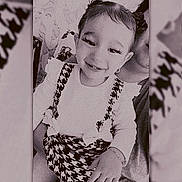 Raymonde Cortez a rejoint le concours — aidez-le/la à gagner de superbes lots ! baby, black_and_white, bracelet, child, cute, dress, eyelashes, face, hand, happy, houndstooth, indoors, monochrome, person, pigtails, portrait, ruffles, sitting, smile, toddler