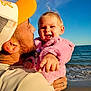 toddler, child, man, beach, ocean, sky, jacket, pink, cap, hat, smile, happy, pointing, holding, portrait, outdoor, water, waves, sunlight, person