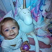 Gaïa participe au concours pour gagner de l'argent avec cette photo : ball, bed, bedding, bedroom, blue_eyes, child, cute, fabric, happy, indoor, pajamas, person, plush_toy, sleepwear, smile, soft_toy, stuffed_animal, toddler, toy, unicorn