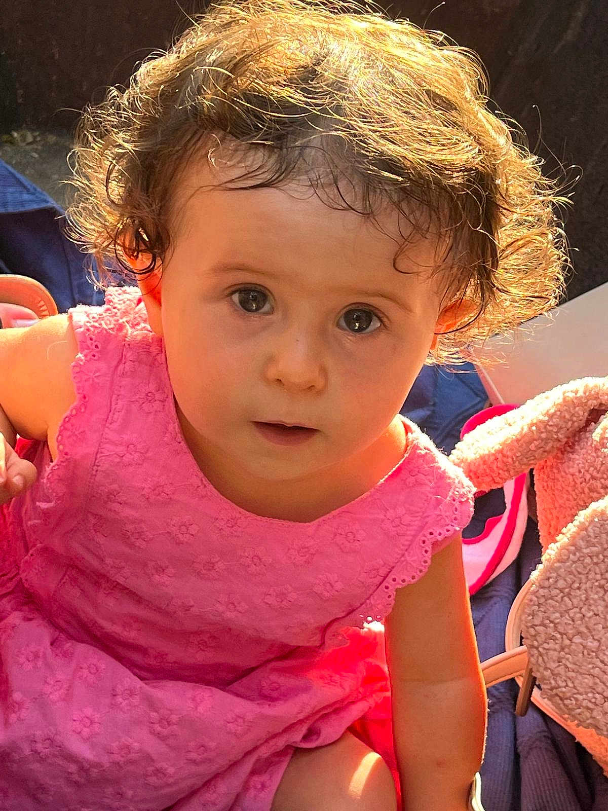 Inès a rejoint le concours — aidez-le/la à gagner de superbes lots ! toddler, child, curly_hair, pink_dress, sunlight, portrait, cute, baby, innocent, face, expression, indoors, soft_toys, blanket, young_child, closeup, person, summer, casual, warm_light