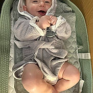Silas joined the competition — help win amazing prizes! baby, smiling, hooded_towel, infant, cushion, changing_pad, cozy, happy, skin, legs, feet, indoors, child, cute, soft_texture, wrapped, clothing, pacifier, relaxing, portrait