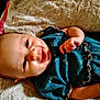 Caityy is registered to the contest to win money with this photo: baby, smiling, infant, face, clothing, blanket, happy, cute, child, portrait, skin, hand, lying_down, young, indoors, soft_texture, rippled_fabric, teal_color, closeup, baby_girl