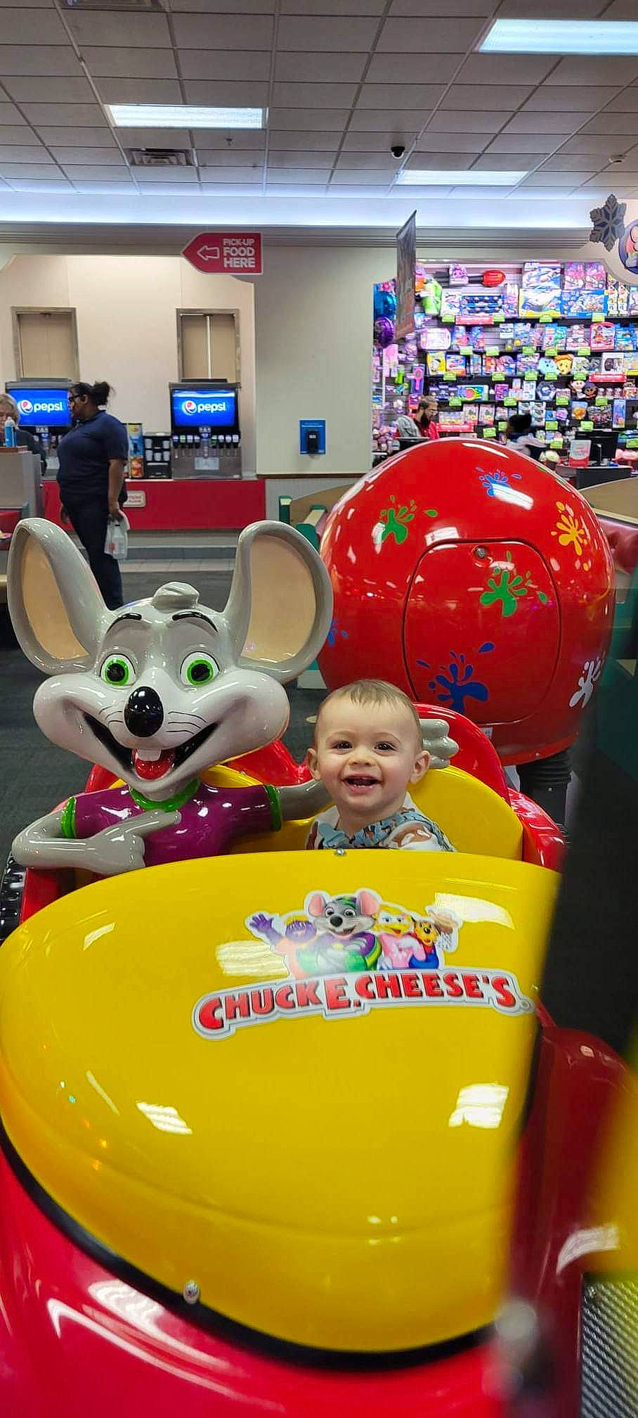 Brian is registered to the contest to win money with this photo: child, event, fun, games, happy, joy, leisure, motor_vehicle, party_supply, people, person, photograph, play, product, public_space, recreation, retail, smile, snapshot, t_shirt