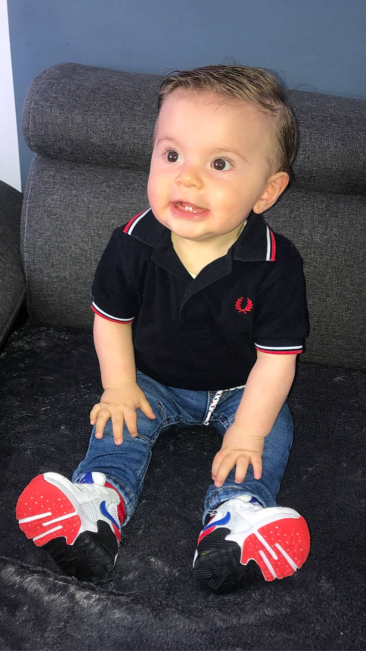 Tiziano participe au concours pour gagner de l'argent avec cette photo : baby, baby_toddler_clothing, carmine, cheek, child, comfort, electric_blue, eye, flooring, fun, human_leg, lap, person, product, red, sitting, sleeve, sock, standing, toddler