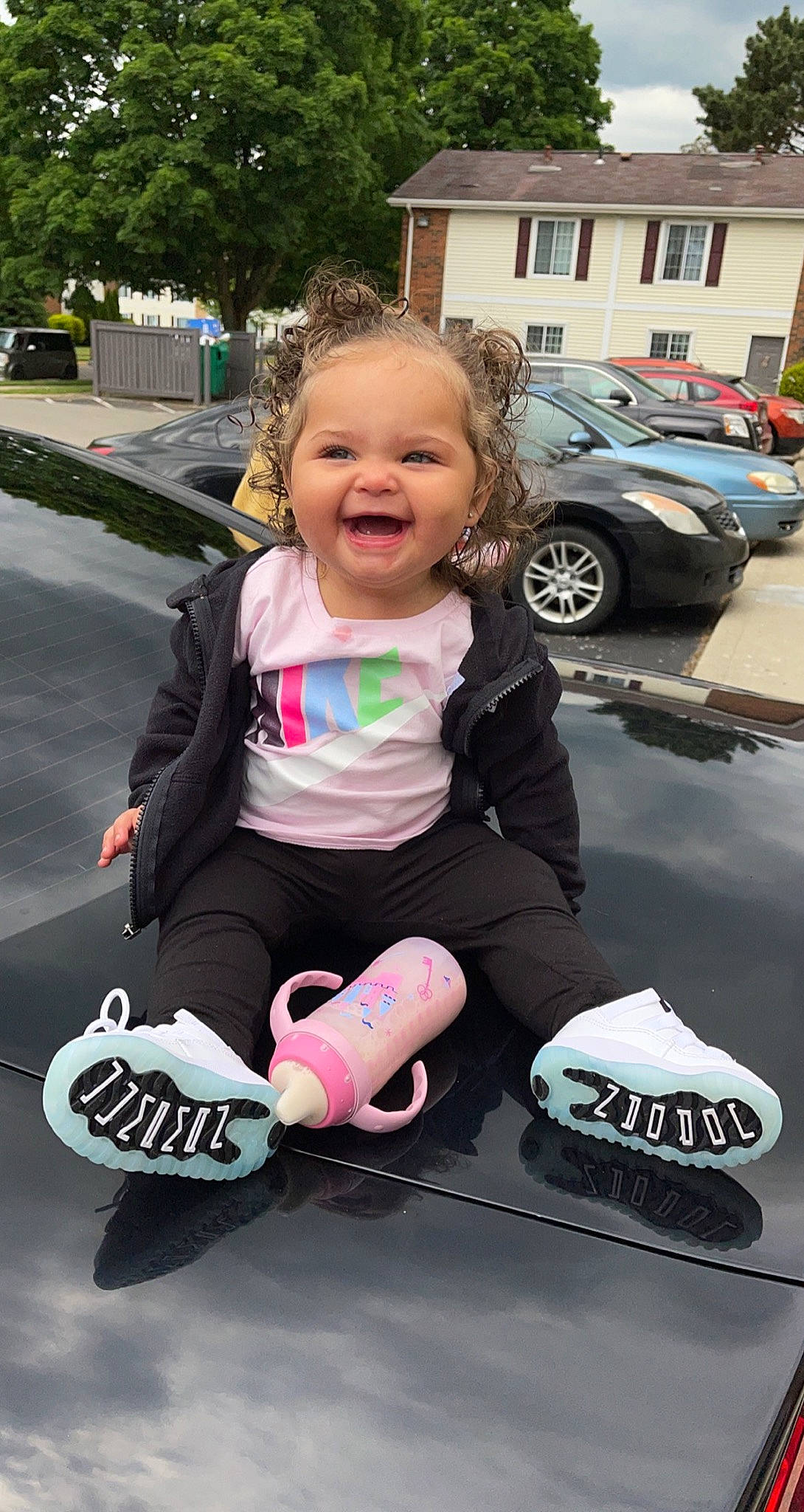 Kamarii is registered to the contest to win money with this photo: automotive_design, automotive_tire, baby_toddler_clothing, car, child, fun, happy, motor_vehicle, outerwear, person, pink, recreation, sleeve, smile, t_shirt, tire, toddler, travel, tree, vehicle