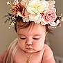 baby, flower_crown, necklace, portrait, cute, infant, soft_light, skin, face, chubby, closeup, adorable, child, young, headwear, natural_light, expression, peaceful, indoors, person