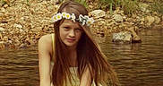 Grace is registered to the contest to win money with this photo: child, girl, flower_crown, yellow_dress, long_hair, water, shallow_water, rocks, grass, nature, outdoor, portrait, serene, crouching, summer, river, fairy_tale, calm, young, fashion