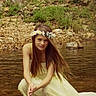 child, girl, flower_crown, yellow_dress, long_hair, water, shallow_water, rocks, grass, nature, outdoor, portrait, serene, crouching, summer, river, fairy_tale, calm, young, fashion