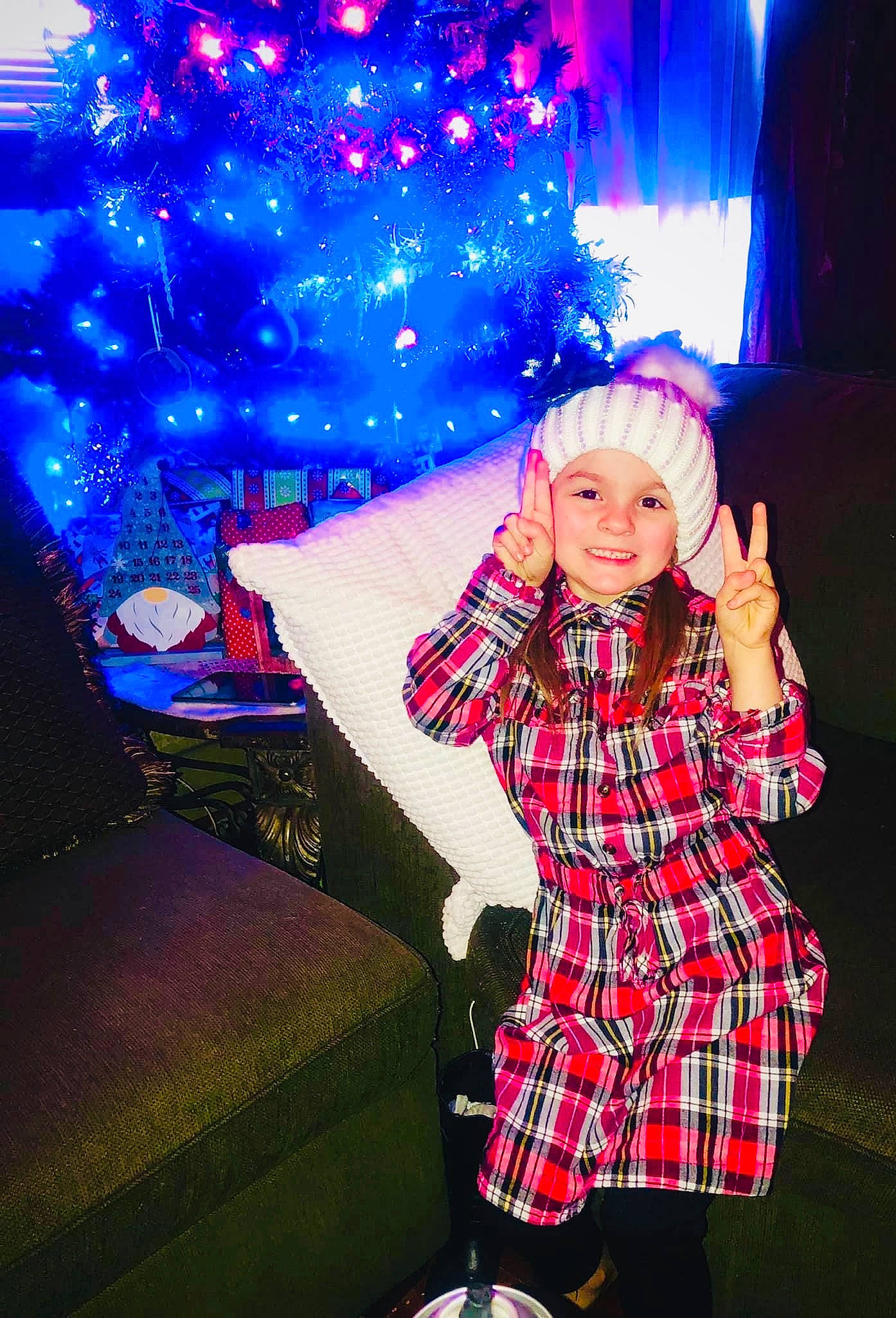Hailey is registered to the contest to win money with this photo: beauty, blue, christmas_tree, couch, electric_blue, entertainment, event, flash_photography, fun, happy, headwear, joy, light, lighting, magenta, person, pink, plaid, purple, smile