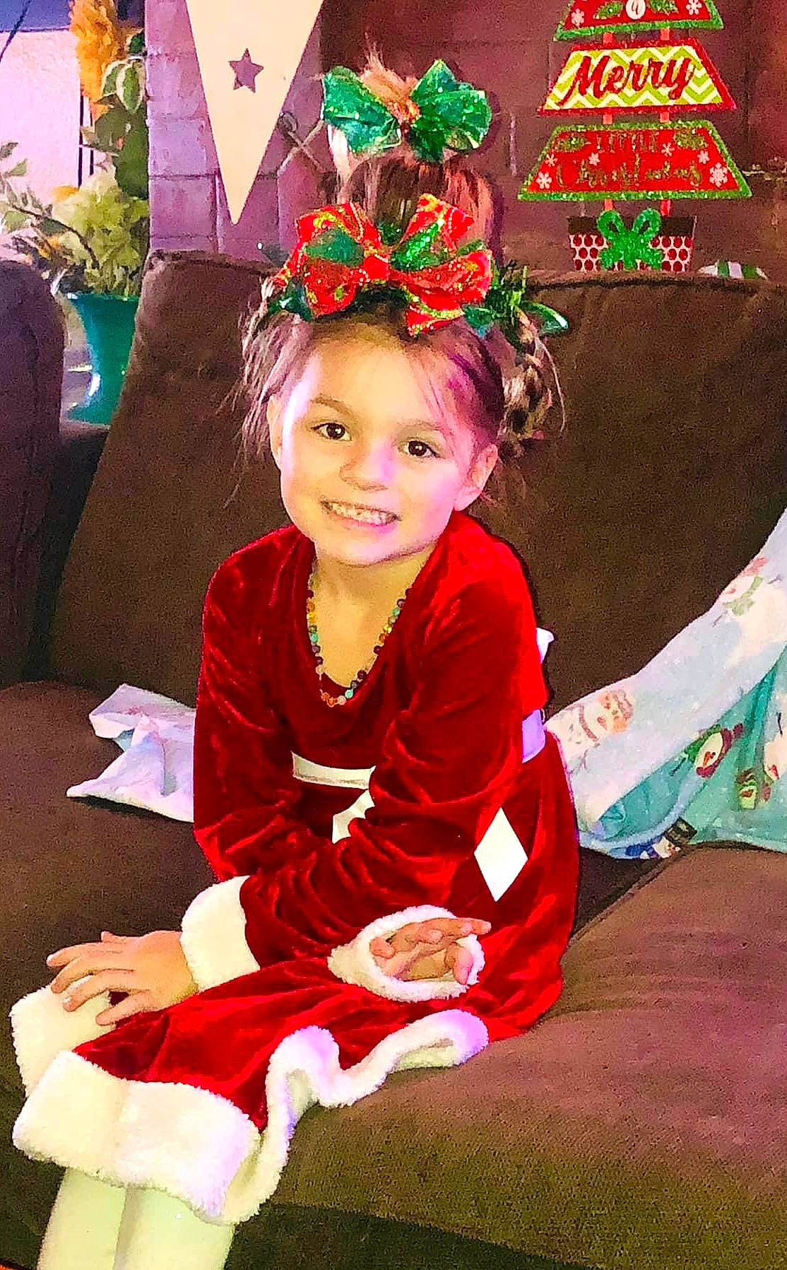 Hailey joined the competition — help win amazing prizes! child, christmas, christmas_eve, event, facial_expression, flower, fun, green, happy, headpiece, holiday, jewellery, joy, lap, magenta, person, pink, plant, sitting, smile