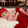Sofia joined the competition — help win amazing prizes! baby, infant, red_bow, red_blanket, white_blanket, portrait, indoors, holiday, gifts, wrapped_presents, cute, lying_down, soft_texture, cozy, newborn, child, face, skin, headwear, blanket