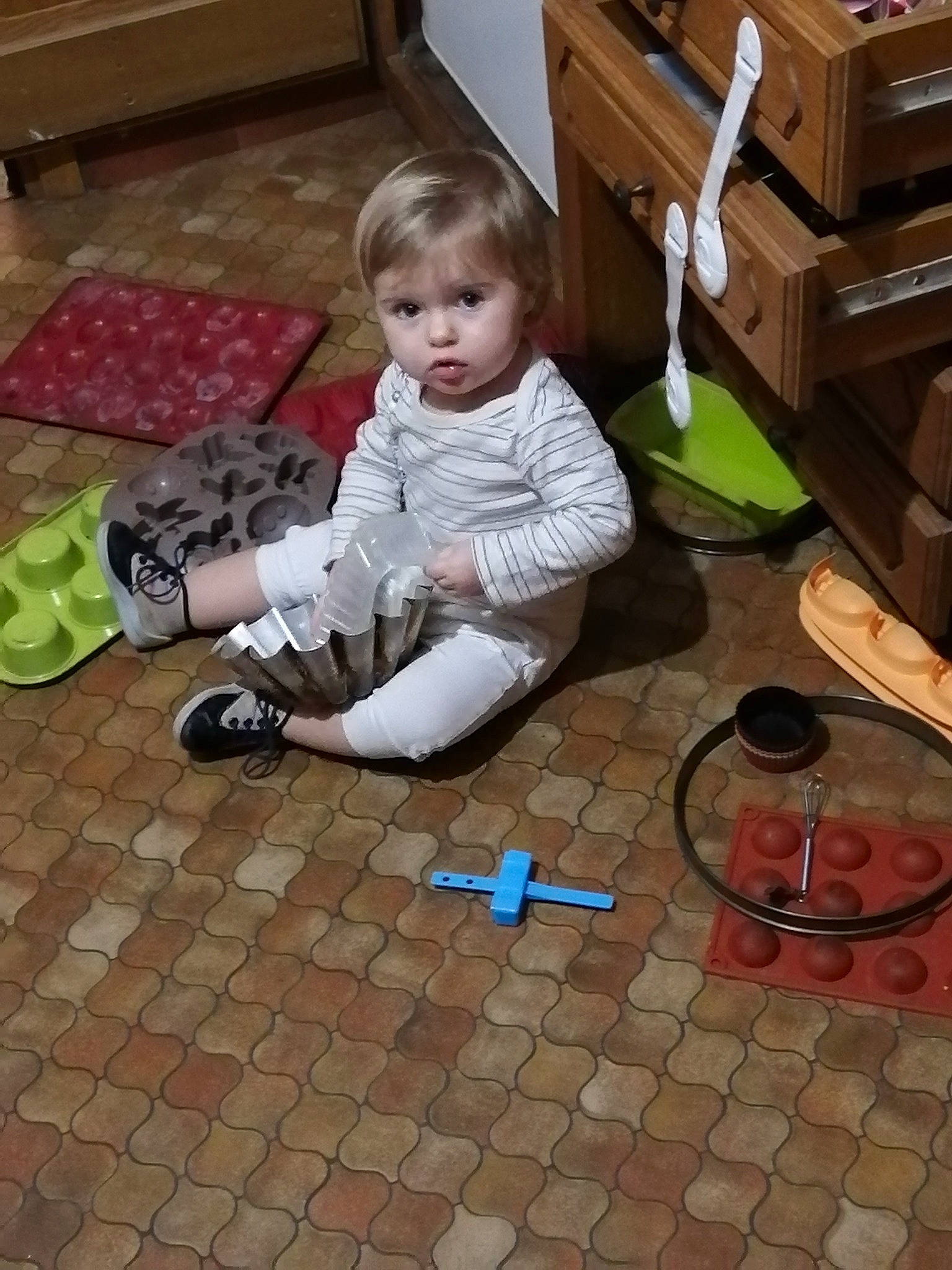 Elyne participe au concours pour gagner de l'argent avec cette photo : baby, baby_toddler_clothing, brickwork, cabinetry, chest_of_drawers, child, cupboard, drawer, floor, flooring, foot, hardwood, human_leg, office_supplies, person, room, sidewalk, sitting, sneakers, toddler